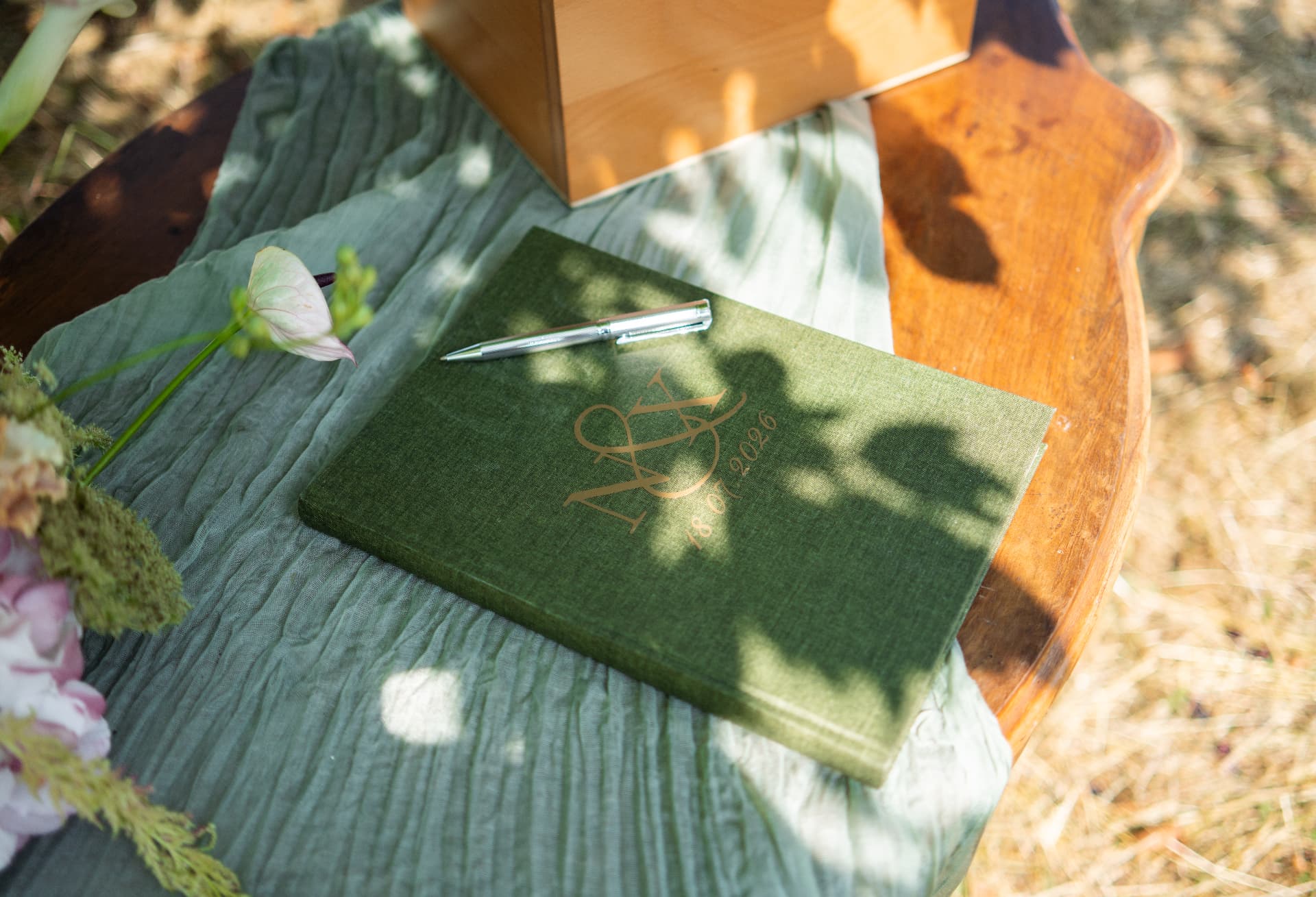 Green guest book on a wooden table