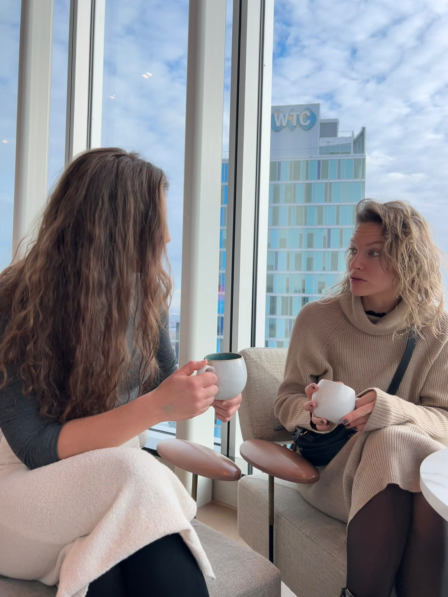 Two women deep in conversation over tea in daylight
